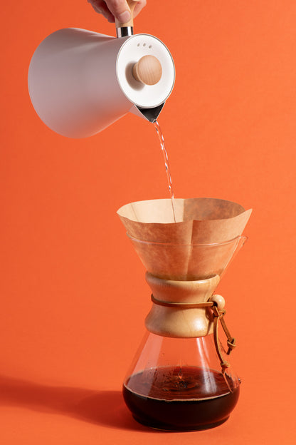 Une bouilloire verse de l'eau chaude dans une cafetière filtre pour infuser de la chicorée Chico