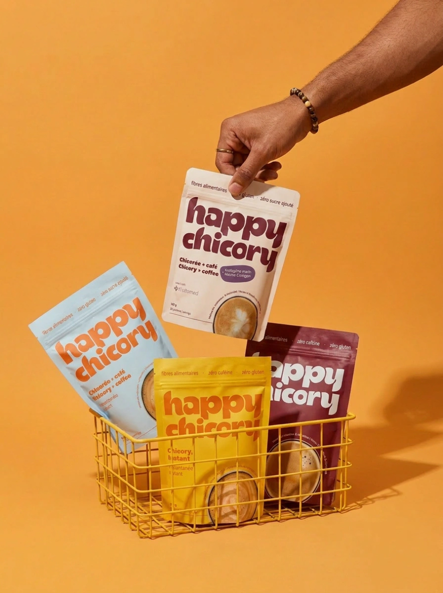 Une main prend un sac de chicorée Happy Chicory dans un panier